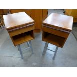 A pair of teak bedside cabinets on metal stands