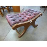 A mahogany and oxblood red leather Chesterfield stool