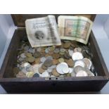A collection of British and foreign coins and bank notes in a wooden box