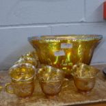 A carnival glass punch bowl and twelve cups