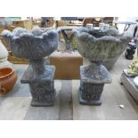 A pair of concrete planters on pedestals