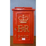 A red painted cast iron post box, with key