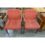 A pair of teak elbow chairs