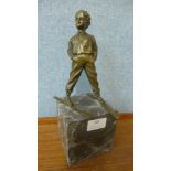 A bronze figure of a young boy on skis, on grey marble socle