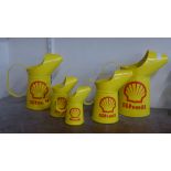 A set of five graduated painted metal Shell oil cans