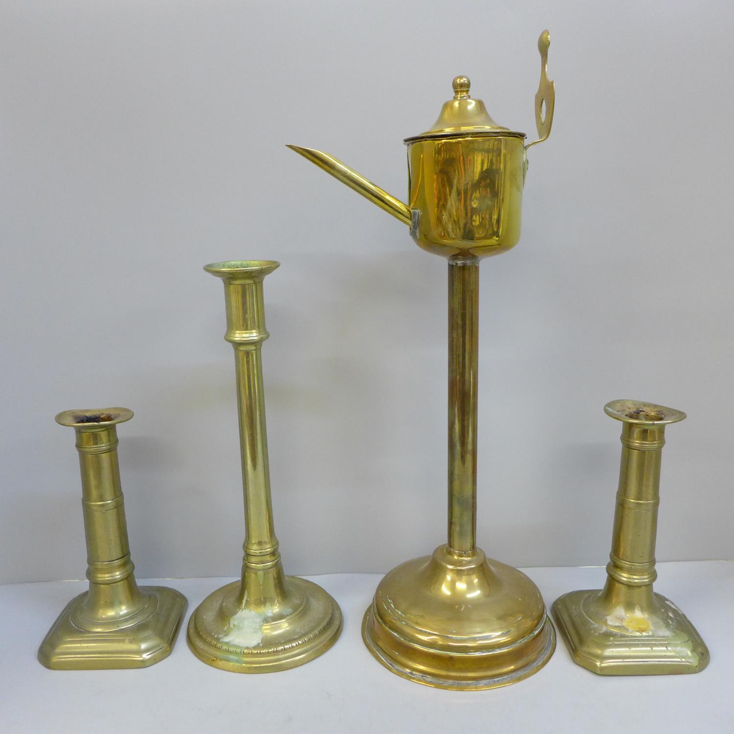 A Georgian brass whale oil lamp, a pair of gun barrel candlesticks and a tall single candlestick