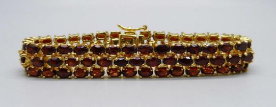 A silver gilt, three row garnet bracelet