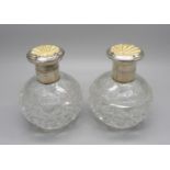 A pair of silver and enamel cut glass scent bottles, Birmingham 1934, enamel a/f on one