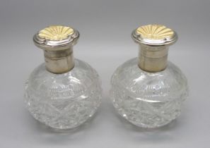 A pair of silver and enamel cut glass scent bottles, Birmingham 1934, enamel a/f on one