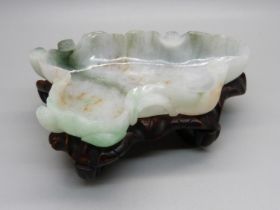 A jade dish on a wooden stand, length 12.5cm