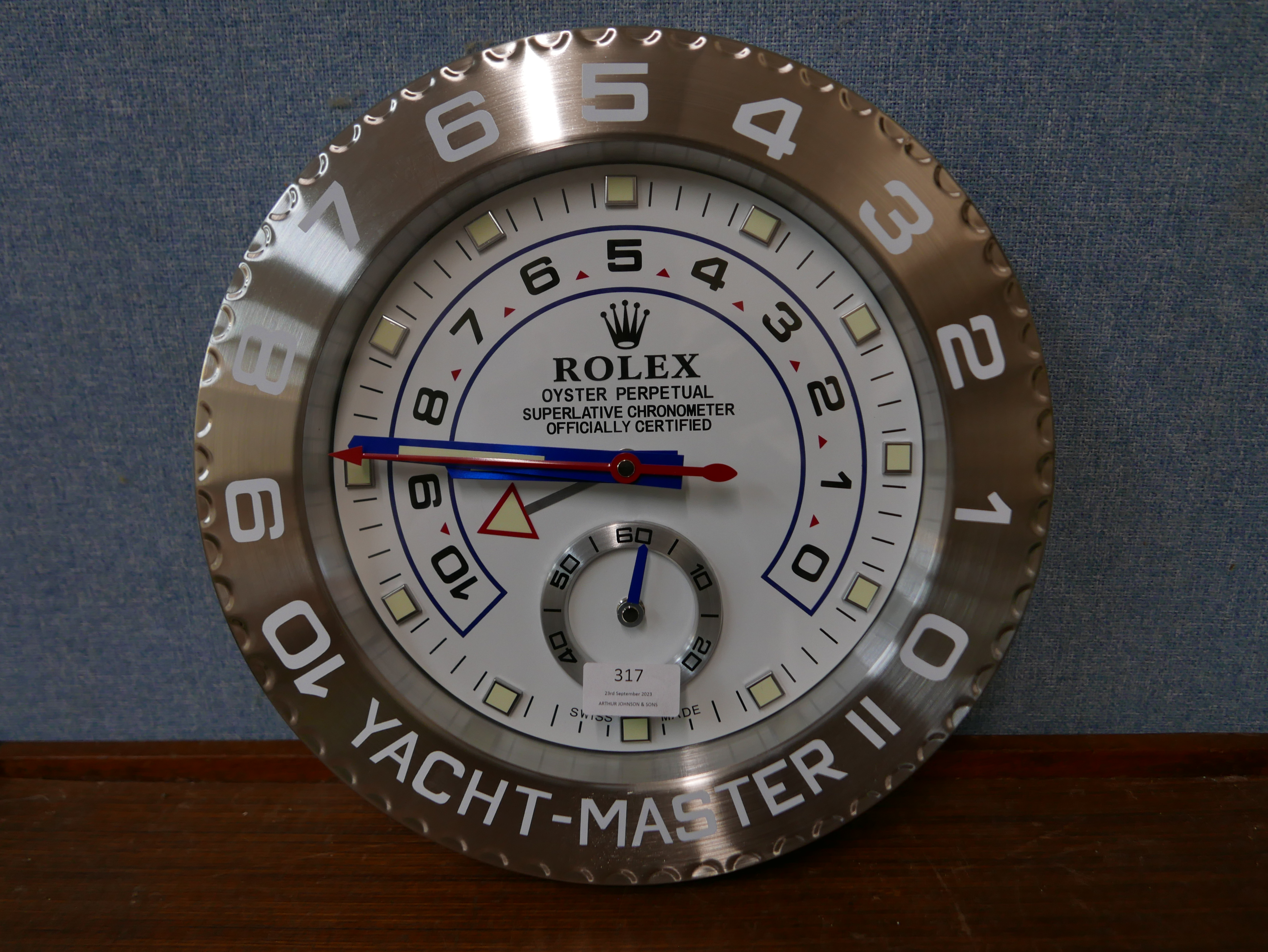 A Rolex style dealer's display wall clock