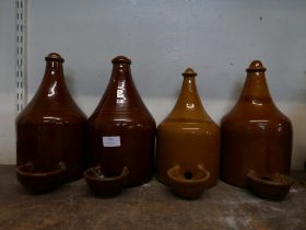 A set of four vintage stoneware chicken drinkers