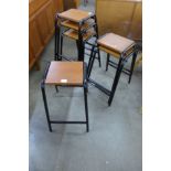 A set of six teak and black tubular metal stools