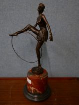 An Art Deco style bronze figure of a female dancing hoop girl, on rouge marble socle