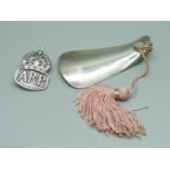 A silver ARP badge and a silver child's shoe horn