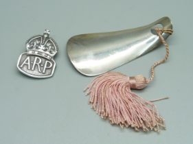 A silver ARP badge and a silver child's shoe horn