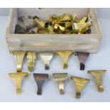 A wooden box containing thirty-three brass picture rail hooks