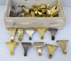A wooden box containing thirty-three brass picture rail hooks