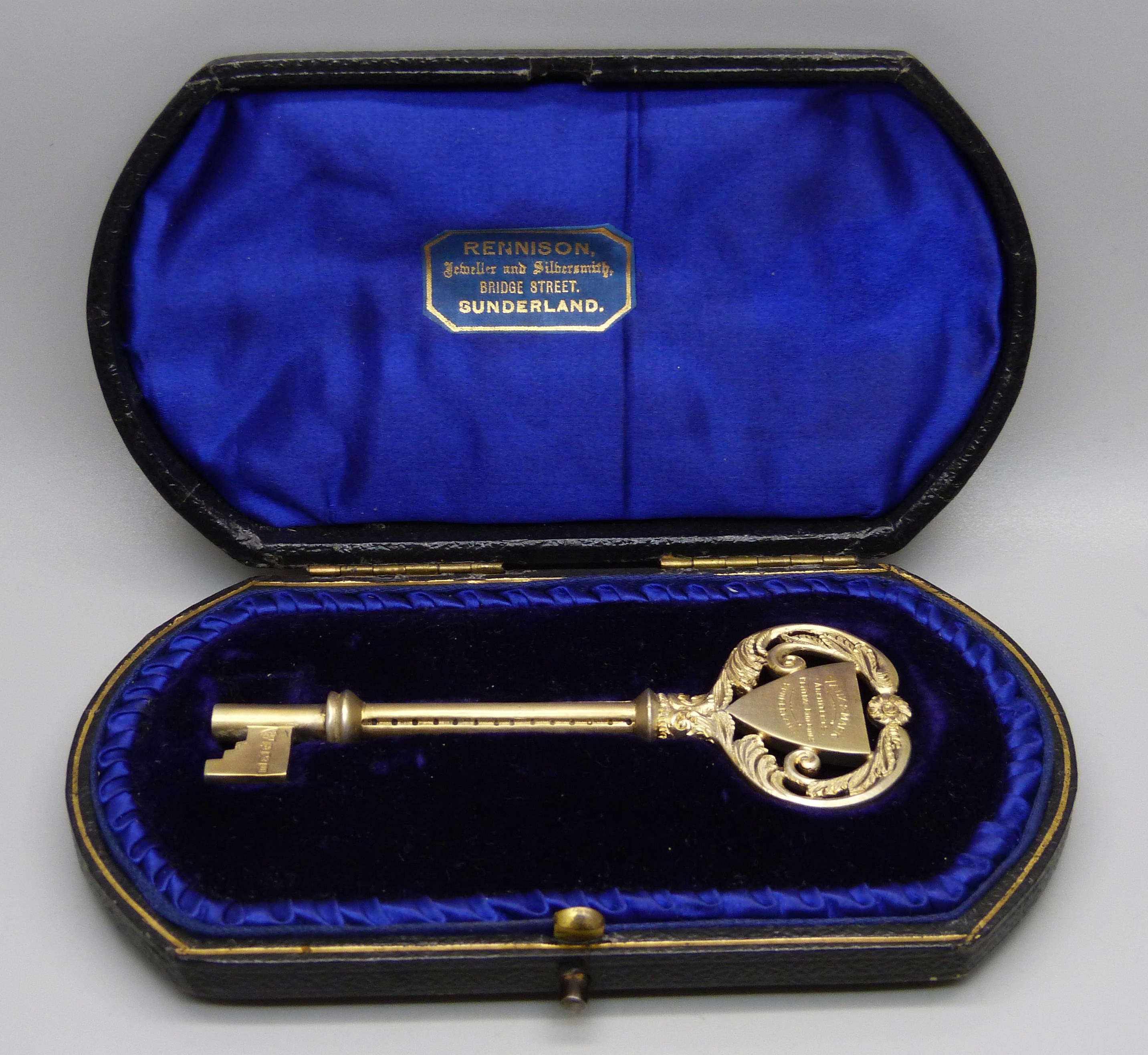 A silver gilt key in original fitted case, Birmingham 1911, with inscription, 43g