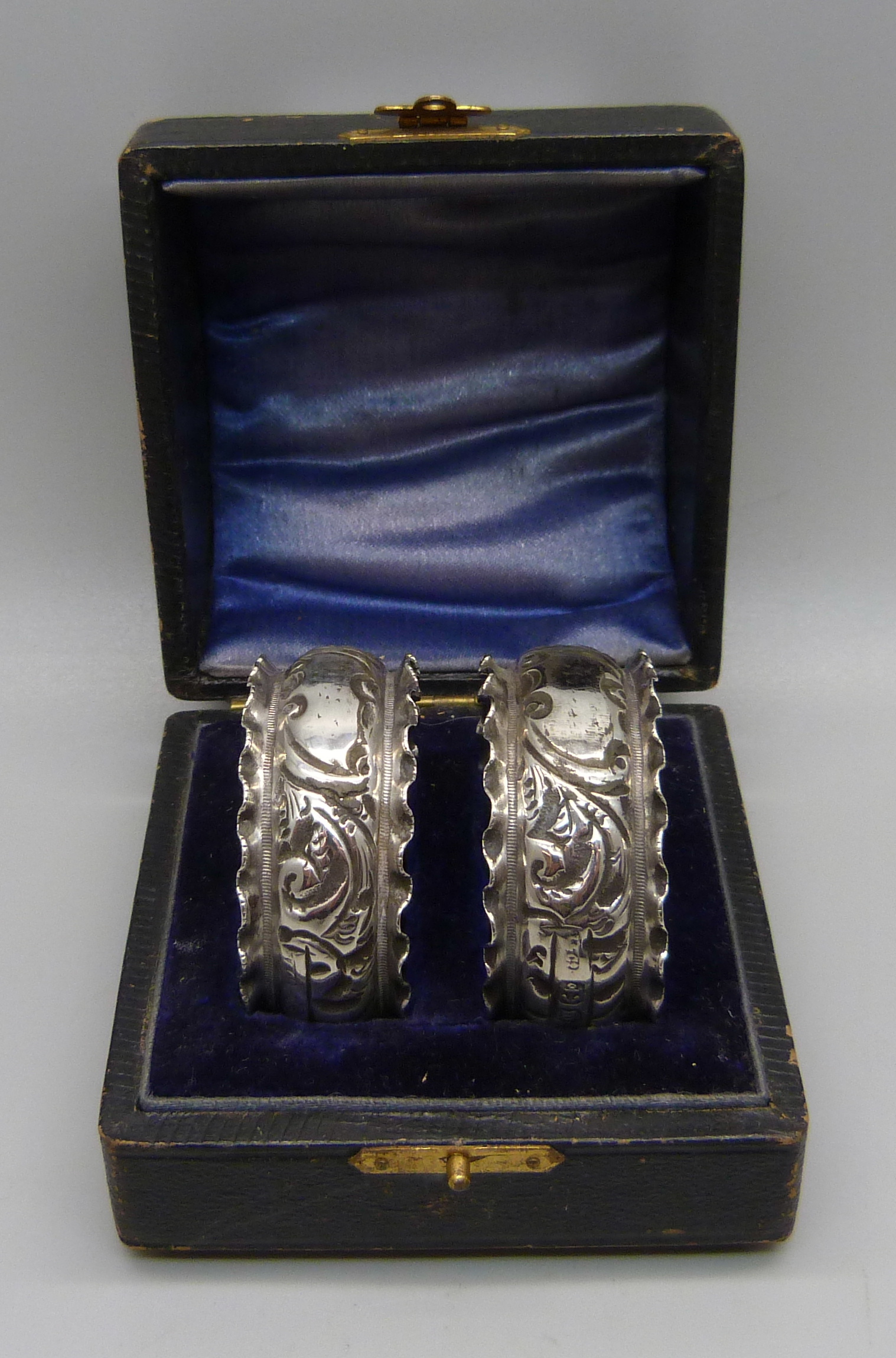 A pair of Victorian silver napkin rings in fitted case, Birmingham 1896, inscription erased