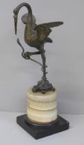A bronze model of a bird standing on a turtle, on a quartz base