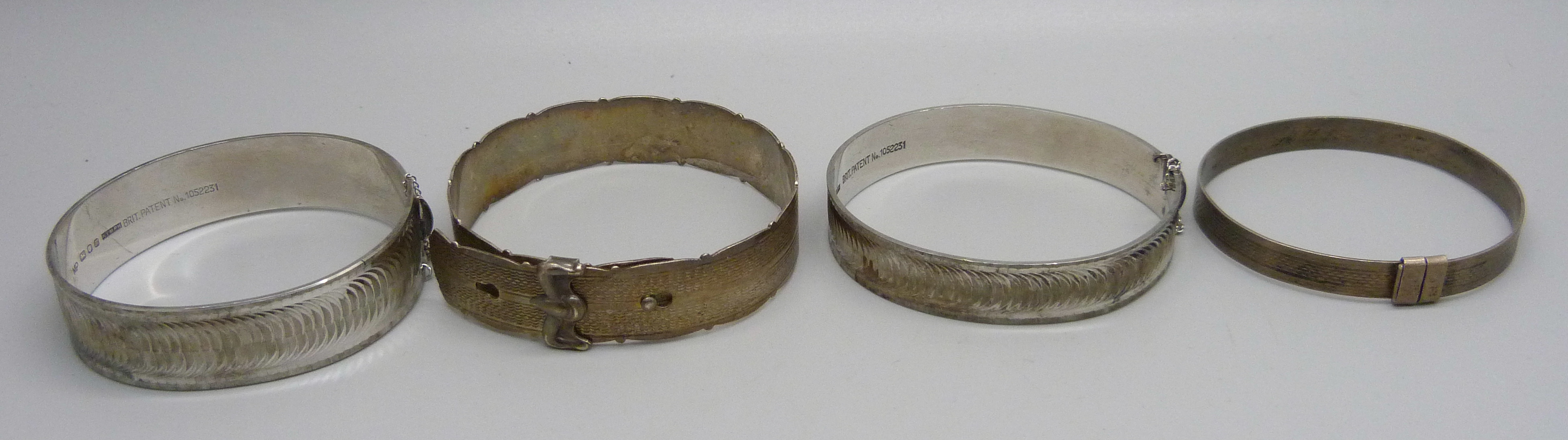 Four silver bangles including one buckle style with Edinburgh hallmark, 79g