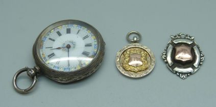 A silver pocket watch, 4cm case, and two gold fronted silver fob medals