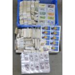 A large collection of cigarette cards and tea cards in two trays, covering many themes, cards in