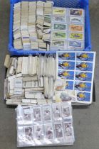 A large collection of cigarette cards and tea cards in two trays, covering many themes, cards in