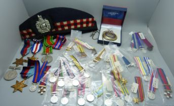 Five WWII medals, a collection of replica miniature medals, a military cap, a badge and a pocket