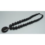 A Victorian carved jet bead necklace with locket