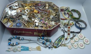 A tin of costume jewellery