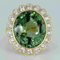 An 18ct yellow gold, 11.82ct oval cut green tourmaline and diamond ring, 1.14ct diamond weight