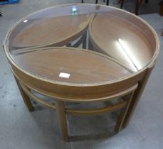 A circular Nathan Trinity teak and glass topped nest of tables