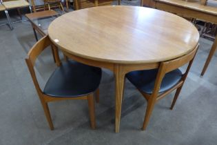 A Nathan teak circular extending dining table and four chairs
