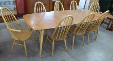 An Ercol Blonde elm and beech Grand Windsor extending dining table and eight Ercol Blonde Quaker