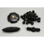 Two Victorian carved jet brooches, leaf pattern and one set with stones, and two other brooches, ('