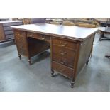 An Edward VII oak and faux leather topped library desk