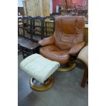 A Norweigan Ekorness beech and leather revolving lounge chair and an ottoman
