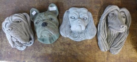 Four assorted concrete wall mounted garden dog's heads
