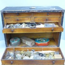 A cabinet with drawers and lockable front with a collection of watch spares