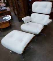 A Charles & Ray Eames style simulated rosewood and white leather revolving lounge chair and ottoman