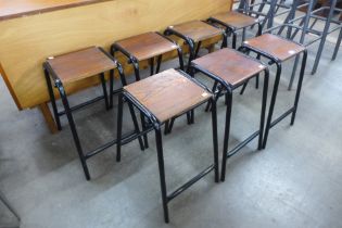 A set of seven oak and black tubular steel stools