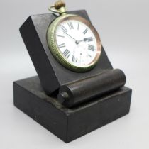 A military issue pocket watch on a black stand, marked Patt. 300, 4141, with broad arrow