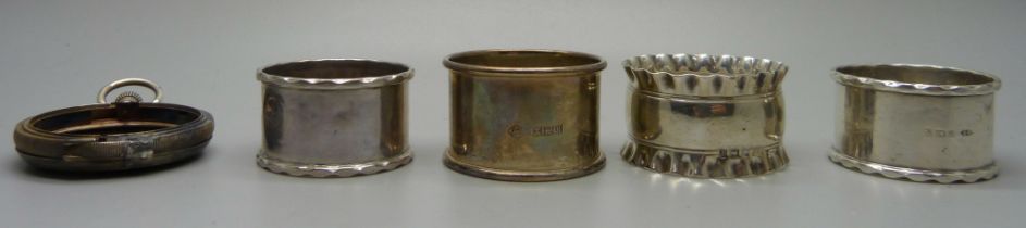 Four silver napkin rings and a silver pocket watch case lacking front, 105g