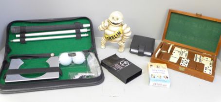 A set of dominoes, a model Michelin man, a golf set, cards, etc.