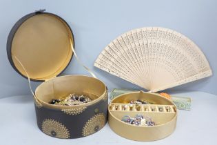 A box of costume jewellery and a fan