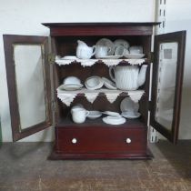 A Victorian apprentices mahogany bookcase with miniature tea set