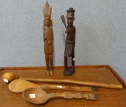 A figure of an African man with paddle, a knobkerrie and two spoons