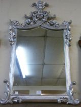 A carved Rococo style silver mirror